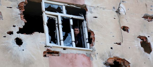 A man looks out of a building which was damaged during the security operations and clashes between Turkish security forces and Kurdish militants, in Sur district of Diyarbakir, Turkey - Sputnik International