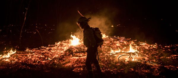 A firefighters tries to extinguish flames A firefighters tries to extinguish flames - Sputnik International