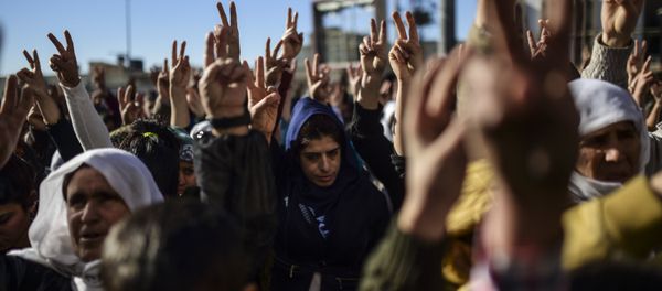 Members of the Kurdish community flash the V for victiry sign during a demonstration in Sirnak - Sputnik International