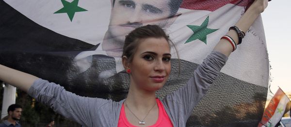 A Syrian girl holds her national flag bearing a portrait of Syria's President Bashar al-Assad A Syrian girl holds her national flag bearing a portrait of Syria's President Bashar al-Assad - Sputnik International
