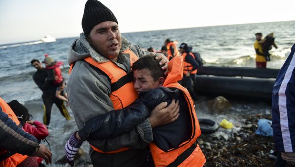 Peopl react after arriving on the Greek island of Lesbos along with other migrants and refugees, on November 17, 2015, after crossing the Aegean Sea from Turkey Peopl react after arriving on the Greek island of Lesbos along with other migrants and refugees, on November 17, 2015, after crossing the Aegean Sea from Turkey - Sputnik International