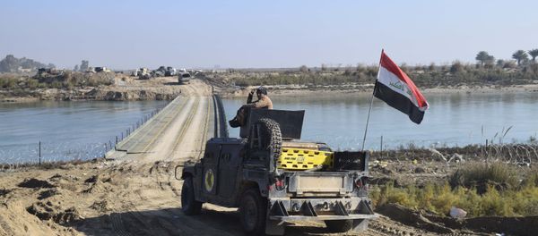 Iraqi security forces cross a bridge built by corps of Engineers over the Euphrates River as Islamic State destroyed all the bridges leading to central Ramadi to block Iraqi security forces from moving forward in Ramadi, 70 miles (115 kilometers) west of Baghdad, Iraq, Tuesday, Dec. 22, 2015 - Sputnik International
