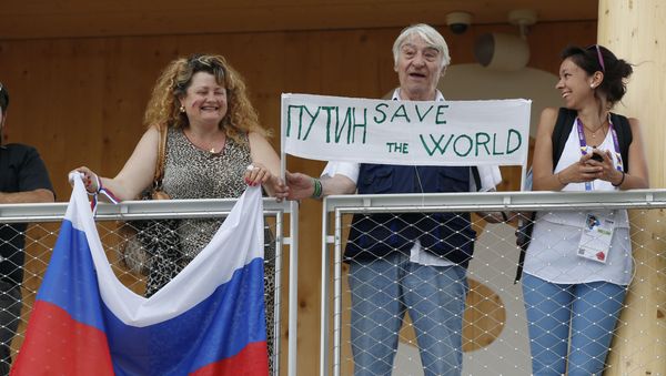 Visitors hold a banner and a Russian flag as Russian President Vladimir Putin arrives for a visit at the Russian pavilion at the 2015 Expo in Rho, near Milan, Italy, Wednesday, June 10, 2015 Visitors hold a banner and a Russian flag as Russian President Vladimir Putin arrives for a visit at the Russian pavilion at the 2015 Expo in Rho, near Milan, Italy, Wednesday, June 10, 2015 - Sputnik International