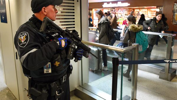 An Amtrak Police officer watches passengersas they board a train at Penn Station on November 24, 2015 in New York. After a string of terror attacks in several countries, the US government issued a worldwide travel alert warning American citizens of increased terrorist threats - Sputnik International