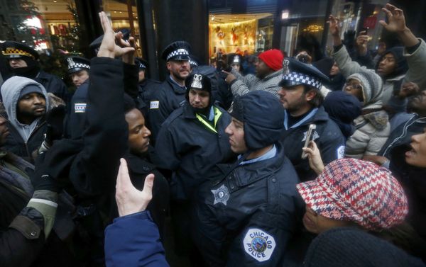 Demonstators hold their hands up in front of Chicago Police officers during protest of last year's shooting death of black teenager Laquan McDonald by a white policeman and the city's handling of the case in the downtown shopping district of Chicago, Illinois, November 27, 2015 Demonstators hold their hands up in front of Chicago Police officers during protest of last year's shooting death of black teenager Laquan McDonald by a white policeman and the city's handling of the case in the downtown shopping district of Chicago, Illinois, November 27, 2015 - Sputnik International