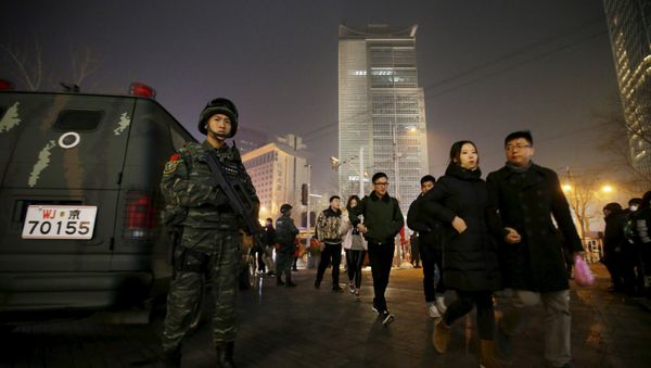 An armed policeman from the Snow Leopard Commando Unit stands guard next to a police van at the Sanlitun area, a fashionable location for shopping and dining, on Christmas Eve in Beijing, China, December 24, 2015. An armed policeman from the Snow Leopard Commando Unit stands guard next to a police van at the Sanlitun area, a fashionable location for shopping and dining, on Christmas Eve in Beijing, China, December 24, 2015. - Sputnik International