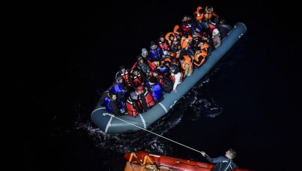 File photo of a member of the Turkish Coast Guard pulls an inflatable dinghy transporting Syrian migrants attempting to reach the Greek island of Chios, in the Agean Sea near Izmir in the night of December 9 to December 10, 2015 File photo of a member of the Turkish Coast Guard pulls an inflatable dinghy transporting Syrian migrants attempting to reach the Greek island of Chios, in the Agean Sea near Izmir in the night of December 9 to December 10, 2015 - Sputnik International