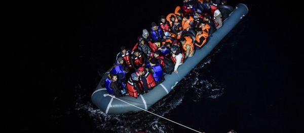 File photo of a member of the Turkish Coast Guard pulls an inflatable dinghy transporting Syrian migrants attempting to reach the Greek island of Chios, in the Agean Sea near Izmir in the night of December 9 to December 10, 2015 File photo of a member of the Turkish Coast Guard pulls an inflatable dinghy transporting Syrian migrants attempting to reach the Greek island of Chios, in the Agean Sea near Izmir in the night of December 9 to December 10, 2015 - Sputnik International
