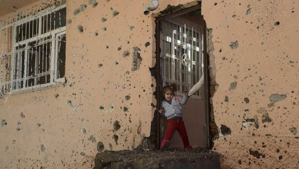A girl stands at the entrance of a damaged house in the Sur district in Diyarbakir on December 11, 2015. - Sputnik International