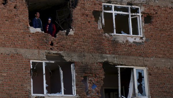 People look out from a building which was damaged during the security operations and clashes between Turkish security forces and Kurdish militants, in Sur district of Diyarbakir, Turkey, December 11, 2015. - Sputnik International