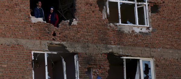 People look out from a building which was damaged during the security operations and clashes between Turkish security forces and Kurdish militants, in Sur district of Diyarbakir, Turkey, December 11, 2015. - Sputnik International