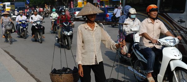 This picture taken on September 10, 2015 shows a migrant worker (C) carrying collected items for recycling walking along a road in downtown Hanoi This picture taken on September 10, 2015 shows a migrant worker (C) carrying collected items for recycling walking along a road in downtown Hanoi - Sputnik International