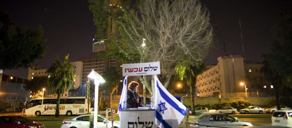 An Israeli activist hands out signs prior to a protest against an investigation into the funding of a number of left-wing NGO's in Israel An Israeli activist hands out signs prior to a protest against an investigation into the funding of a number of left-wing NGO's in Israel - Sputnik International