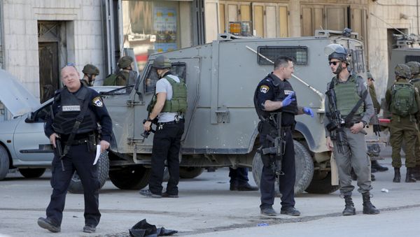 Israeli policemen stand guard near the scene where two Palestinians, who the Israeli military said stabbed and wounded an Israeli soldier, were shot dead by Israeli forces, in the village of Hewara, near the West Bank city of Nablus December 27, 2015 - Sputnik International