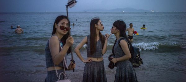 Chinese women pose for a picture on the beach in Qingdao, eastern China's Shandong province on July 24, 2015 - Sputnik International