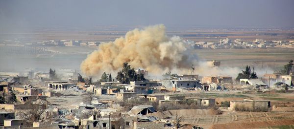 Smoke rises from buildings in the area of Tal Sharba following government air strikes on the outskirts of the northern Syrian city of Aleppo on December 27, 2015, as government forces seized the area from Islamic State (IS) group jihadists - Sputnik International