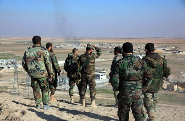 Syrian pro-government fighters look at smoke rising on the horizon following government air strikes on the Tal Sharba area, on the outskirts of the northern Syrian city of Aleppo, after they seized the area from Islamic State (IS) group jihadists on December 27, 2015 - Sputnik International