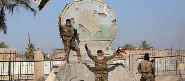 A member of the Iraqi security forces holds an Iraqi flag at a government complex in the city of Ramadi, December 28, 2015 A member of the Iraqi security forces holds an Iraqi flag at a government complex in the city of Ramadi, December 28, 2015 - Sputnik International