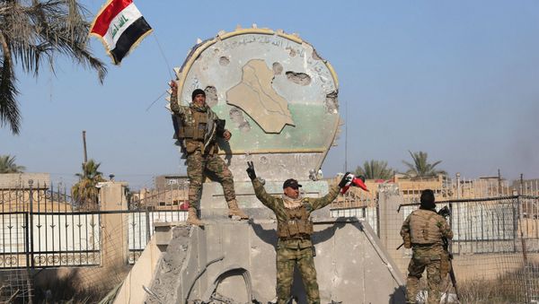 A member of the Iraqi security forces holds an Iraqi flag at a government complex in the city of Ramadi, December 28, 2015 A member of the Iraqi security forces holds an Iraqi flag at a government complex in the city of Ramadi, December 28, 2015 - Sputnik International