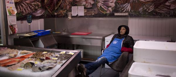 A seller sleeps inside his fish shop as he waits for customers at a market in central Kiev, Ukraine. A seller sleeps inside his fish shop as he waits for customers at a market in central Kiev, Ukraine. - Sputnik International