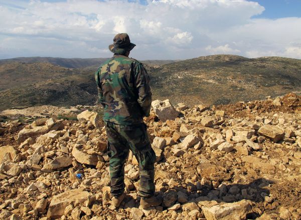 Hezbollah fighter looks toward Syria while standing in the fields of the Lebanese border village of Brital, Lebanon. (File) Hezbollah fighter looks toward Syria while standing in the fields of the Lebanese border village of Brital, Lebanon. (File) - Sputnik International