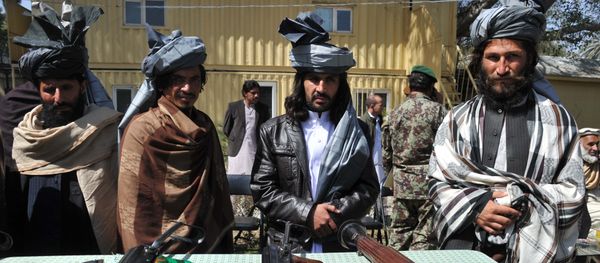 Former Taliban fighters look on as they stand alongside their weapons in Jalalabad, the capital of Nangarhar province on March 19, 2014 - Sputnik International