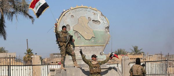 A member of the Iraqi security forces holds an Iraqi flag at a government complex in the city of Ramadi, December 28, 2015 A member of the Iraqi security forces holds an Iraqi flag at a government complex in the city of Ramadi, December 28, 2015 - Sputnik International