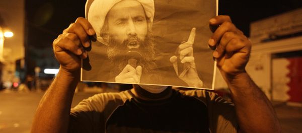 Bahraini anti-government protester holds up a picture of jailed Saudi Sheik Nimr al-Nimr during clashes with riot police in Sanabis, Bahrain, a suburb of the capital Manama Bahraini anti-government protester holds up a picture of jailed Saudi Sheik Nimr al-Nimr during clashes with riot police in Sanabis, Bahrain, a suburb of the capital Manama - Sputnik International