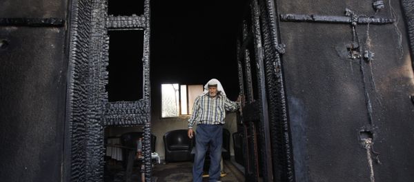 FILE - In this July 31, 2015 file photo, a Palestinian inspects a house after it was torched in a suspected attack by Jewish settlers, killing an 18-month-old Palestinian child and his parents, at Duma village near the West Bank city of Nablus - Sputnik International