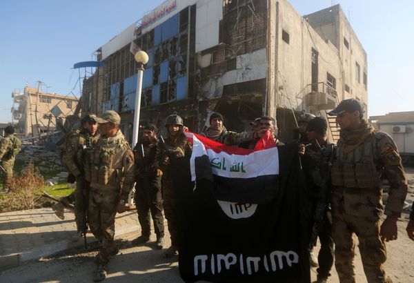 Iraqi security forces place the Iraqi flag above the Islamic State group flag as they pose for a picture on December 28, 2015 in front of the Anbar police headquarters after they recaptured the city of Ramadi, the capital of Iraq's Anbar province, about 110 kilometers west of Baghdad - Sputnik International