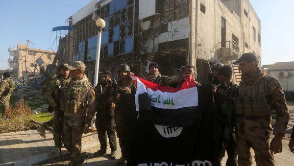 Iraqi security forces place the Iraqi flag above the Islamic State group flag as they pose for a picture on December 28, 2015 in front of the Anbar police headquarters after they recaptured the city of Ramadi, the capital of Iraq's Anbar province, about 110 kilometers west of Baghdad Iraqi security forces place the Iraqi flag above the Islamic State group flag as they pose for a picture on December 28, 2015 in front of the Anbar police headquarters after they recaptured the city of Ramadi, the capital of Iraq's Anbar province, about 110 kilometers west of Baghdad - Sputnik International