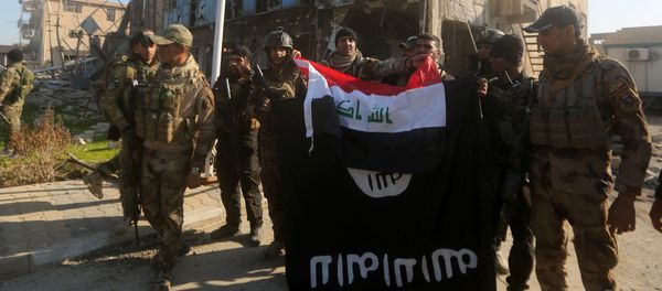Iraqi security forces place the Iraqi flag above the Islamic State group flag as they pose for a picture on December 28, 2015 in front of the Anbar police headquarters after they recaptured the city of Ramadi, the capital of Iraq's Anbar province, about 110 kilometers west of Baghdad Iraqi security forces place the Iraqi flag above the Islamic State group flag as they pose for a picture on December 28, 2015 in front of the Anbar police headquarters after they recaptured the city of Ramadi, the capital of Iraq's Anbar province, about 110 kilometers west of Baghdad - Sputnik International
