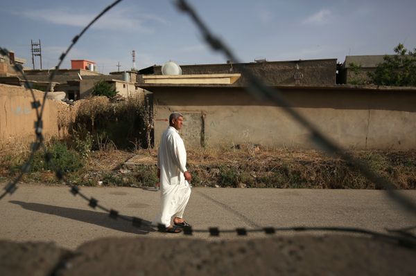 In this Wednesday, May 27, 2015 photo, a resident of Eski Mosul, Iraq is seen through barbed wire while passing the former base of the Islamic State group in the town while it was under the militants' control In this Wednesday, May 27, 2015 photo, a resident of Eski Mosul, Iraq is seen through barbed wire while passing the former base of the Islamic State group in the town while it was under the militants' control - Sputnik International