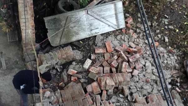 An Indian resident surveys a damaged wall at a house in Imphal on January 4, 2016 - Sputnik International