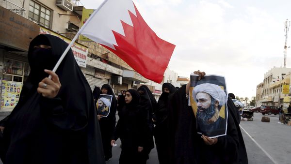 Protesters holding posters of Saudi Shi'ite cleric Nimr al-Nimr and a Bahraini national flag protest against his execution by Saudi authorities in the village of Sanabis, west of Manama, Bahrain January 3, 2016 Protesters holding posters of Saudi Shi'ite cleric Nimr al-Nimr and a Bahraini national flag protest against his execution by Saudi authorities in the village of Sanabis, west of Manama, Bahrain January 3, 2016 - Sputnik International