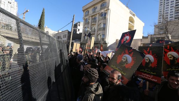 Iranian riot police block a street leading to the Saudi embassy as protesters hold portraits of prominent Shiite Muslim cleric Nimr al-Nimr during a demonstration against his execution by Saudi authorities, on January 3, 2016, in Tehran Iranian riot police block a street leading to the Saudi embassy as protesters hold portraits of prominent Shiite Muslim cleric Nimr al-Nimr during a demonstration against his execution by Saudi authorities, on January 3, 2016, in Tehran - Sputnik International