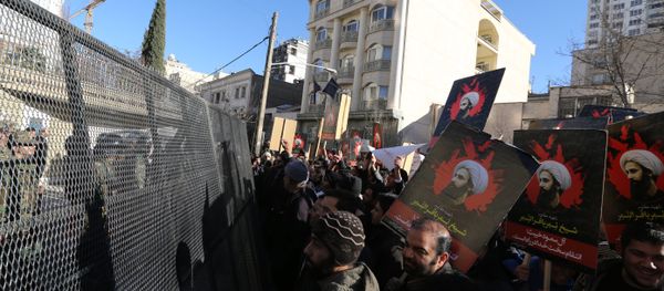Iranian riot police block a street leading to the Saudi embassy as protesters hold portraits of prominent Shiite Muslim cleric Nimr al-Nimr during a demonstration against his execution by Saudi authorities, on January 3, 2016, in Tehran - Sputnik International