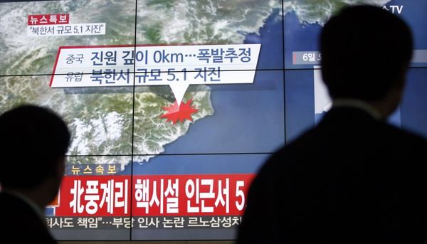 People in Seoul, South Korea walk by a jumbo screen showing news reporting an earthquake near North Korea's nuclear facility, Jan. 6, 2016. - Sputnik International