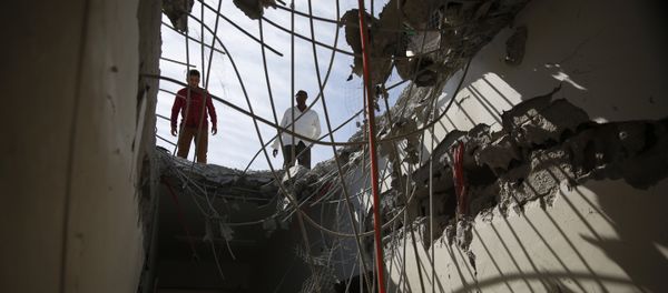 Men inspect a building damaged by a Saudi-led airstrike in Sanaa. - Sputnik International
