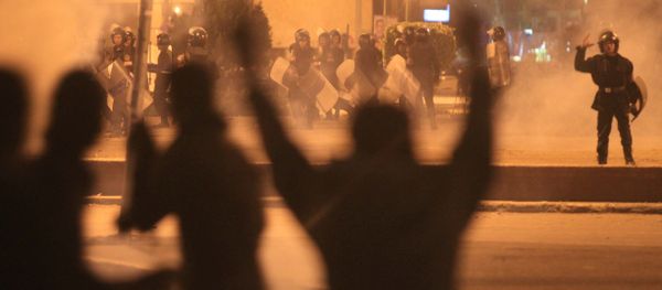 Egyptian protesters gesture as they clash with riot police at Cairo's landmark Tahrir Square on November 19, 2011, as Egyptian police fired rubber bullets and tear gas to break up a sit-in among whose organisers were people injured during the Arab Spring which overthrew veteran president Hosni Mubarak - Sputnik International