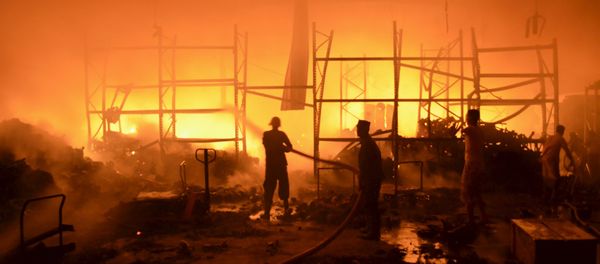 Firefighters attempt to extinguish a fire at a foodstuff storage facility destroyed by a Saudi-led air strike in Yemen's Red Sea port city of Houdieda January 6, 2016. - Sputnik International