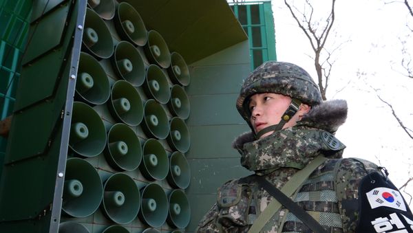 South Korean soldier stands guard in front of loudspeakers as the military prepares propaganda broadcasts near the border area between South Korea and North Korea in Yeoncheon, northeast of Seoul, on January 8, 2016 - Sputnik International