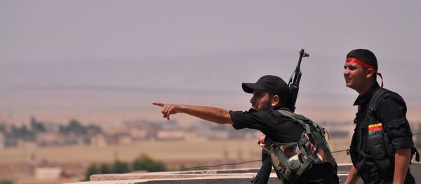 Fighters from the Kurdish People Protection Unit (YPG) monitor the horizon in the northeastern Syrian city of Hasakeh - Sputnik International