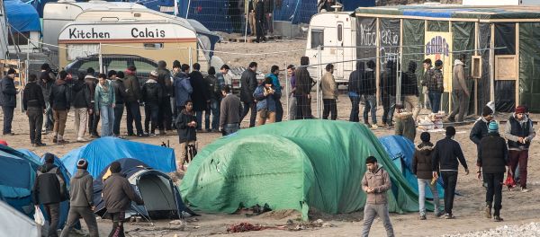 People walk at the migrant camp known as the Jungle in Calais on December 7, 2015 People walk at the migrant camp known as the Jungle in Calais on December 7, 2015 - Sputnik International