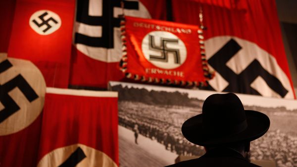 A man looks at exhibit showing the Nazi flags. A man looks at exhibit showing the Nazi flags. - Sputnik International