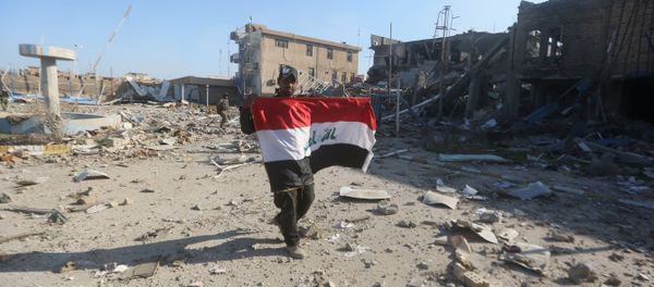 A member of the Iraqi security forces holds his national flag on December 28, 2015 at the heavily damaged government complex after they recaptured the city of Ramadi, the capital of Iraq's Anbar province, about 110 kilometers west of Baghdad, from Islamic States group jihadists A member of the Iraqi security forces holds his national flag on December 28, 2015 at the heavily damaged government complex after they recaptured the city of Ramadi, the capital of Iraq's Anbar province, about 110 kilometers west of Baghdad, from Islamic States group jihadists - Sputnik International