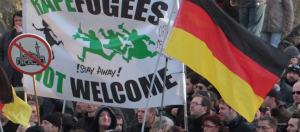 Right-wing demonstrators hold a sign Rapefugees not welcome - !Stay away! and a sign with a crossed out mosque as they march in Cologne, Germany Saturday Jan. 9, 2016 - Sputnik International