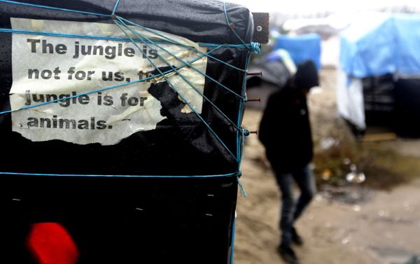 In this Friday, Nov. 6, 2015 file photo, a man walks beside a decomposing poster reading 'The jungle is not for us, the jungle is for animals' fixed by a Sudanese refugee at a tent, inside the migrants camp near Calais, northern France. In this Friday, Nov. 6, 2015 file photo, a man walks beside a decomposing poster reading 'The jungle is not for us, the jungle is for animals' fixed by a Sudanese refugee at a tent, inside the migrants camp near Calais, northern France. - Sputnik International