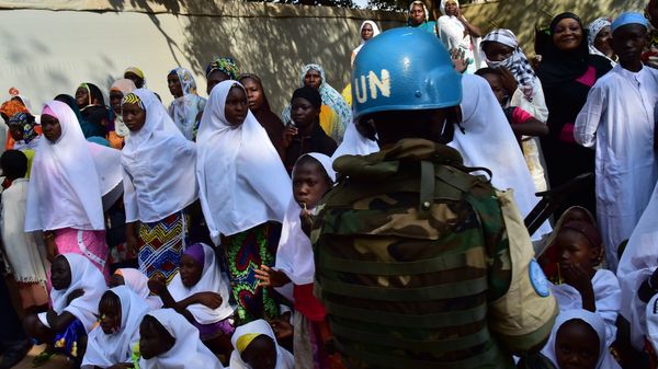 A soldier of the United Nations (UN) stands guard next to girls and women at the Bangui Mosque, Central African Republic, on November 30, 2015. - Sputnik International