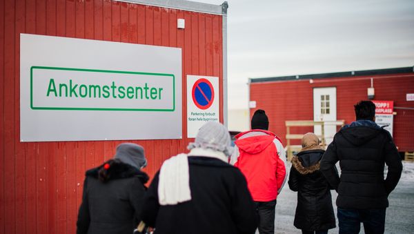 Refugees enter the arrival center for refugees near the town on Kirkenes, northern Norway, close to the Russian - Norwegian border on November 12, 2015. Refugees enter the arrival center for refugees near the town on Kirkenes, northern Norway, close to the Russian - Norwegian border on November 12, 2015. - Sputnik International